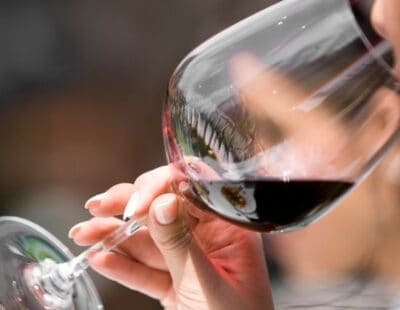 Close-up of someone drinking red wine from a large glass