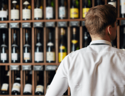 Image of a man looking at bottles of wine in a store. Discovering alcohol-free alternatives: a wine trade insider's perspective.