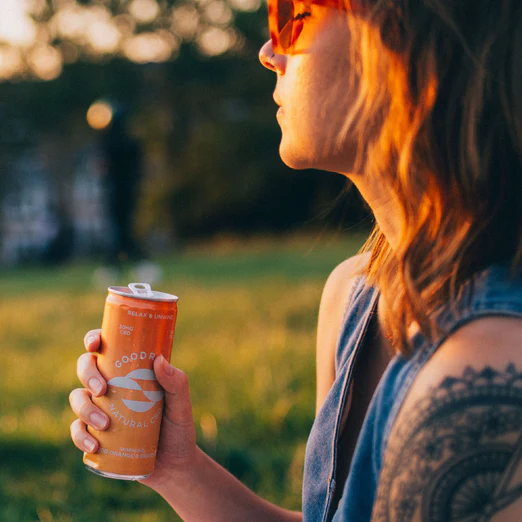 A woman holding a Goodrays can in park